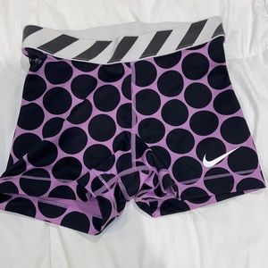 Nike pros: black dots and purple spanks with a white and gray striped waistband